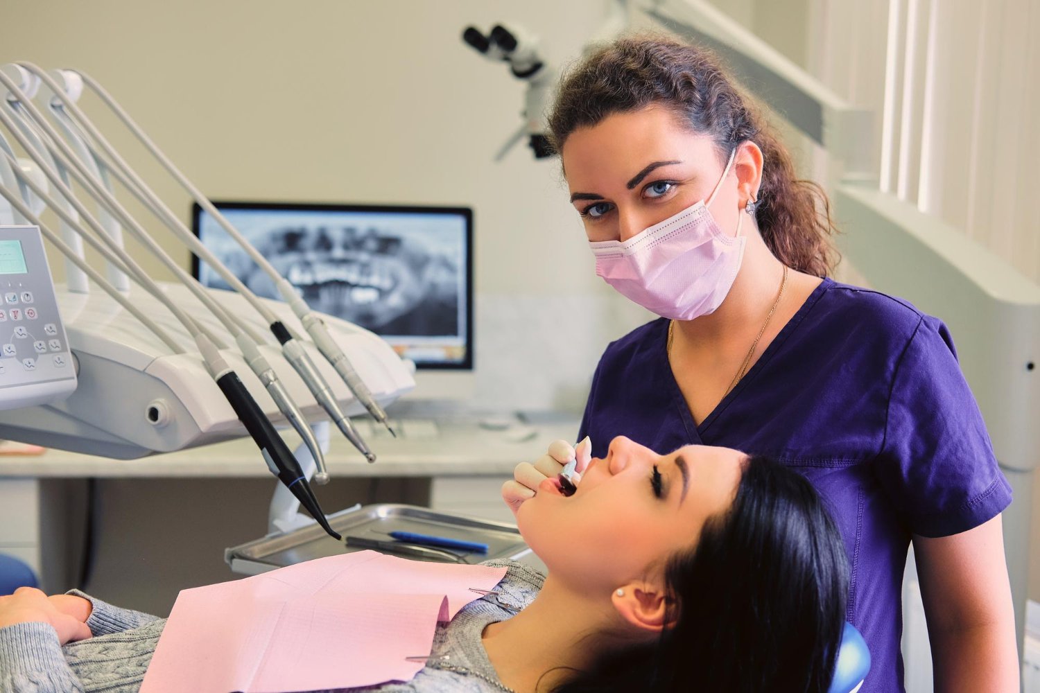 Close-up of a dentist examining a female patient's teeth during a dental checkup, representing quality dental care supported by accurate dental billing services and claims management.